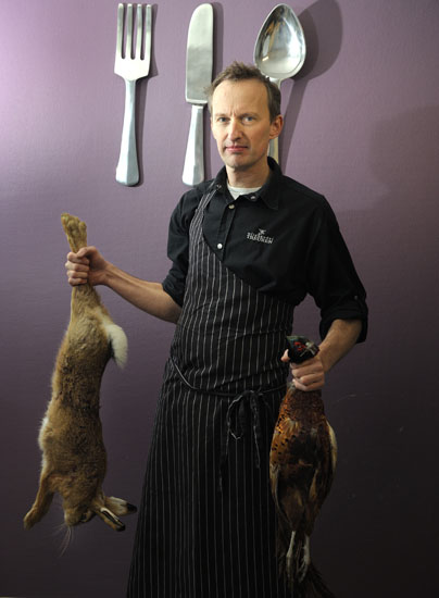 kok met konijn en kalkoen in handen
